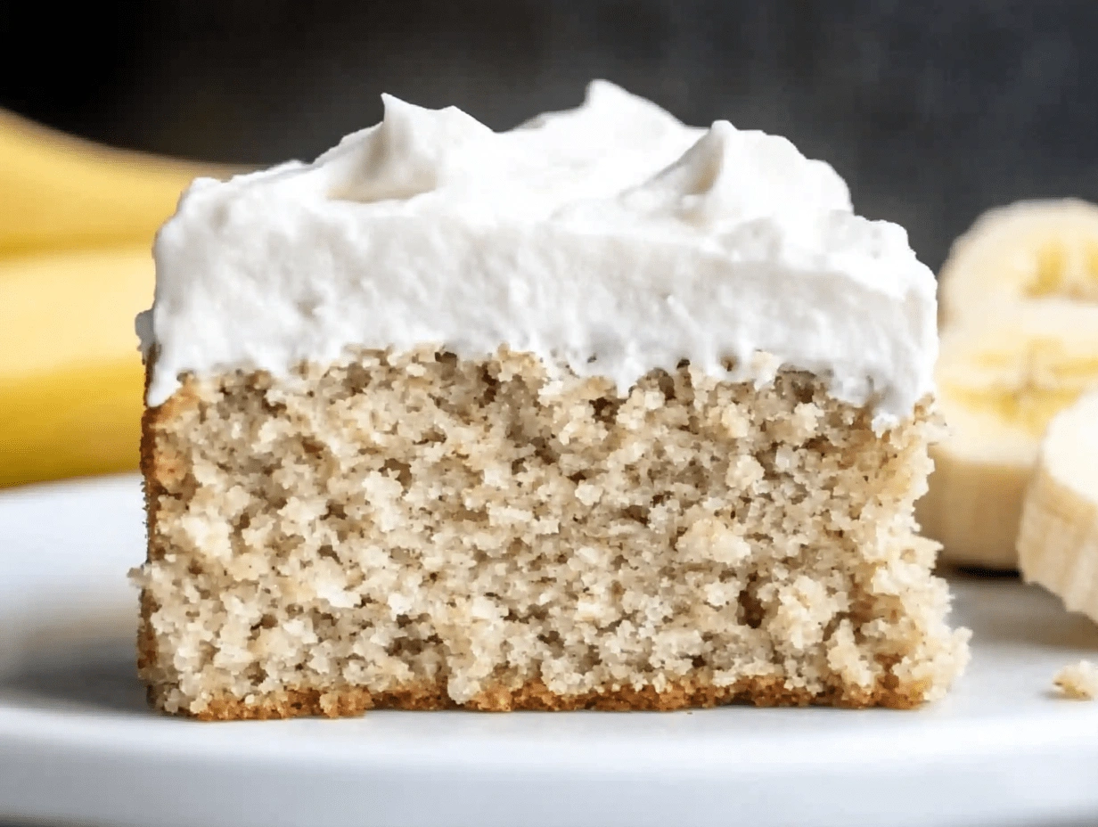 moist-healthy-banana-cake-slice Front view of a moist healthy banana cake slice with thick whipped frosting on top