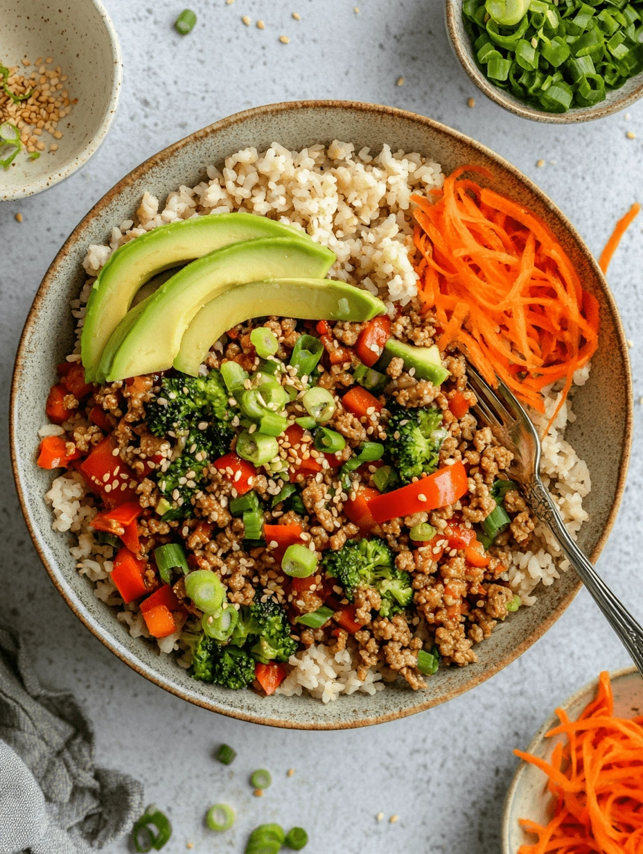 teriyaki-turkey-rice-bowl-overhead-avocado-veggies Overhead view of a Teriyaki Turkey Rice Bowl with avocado slices, shredded carrots, green onions, broccoli, and red bell peppers served over brown rice.