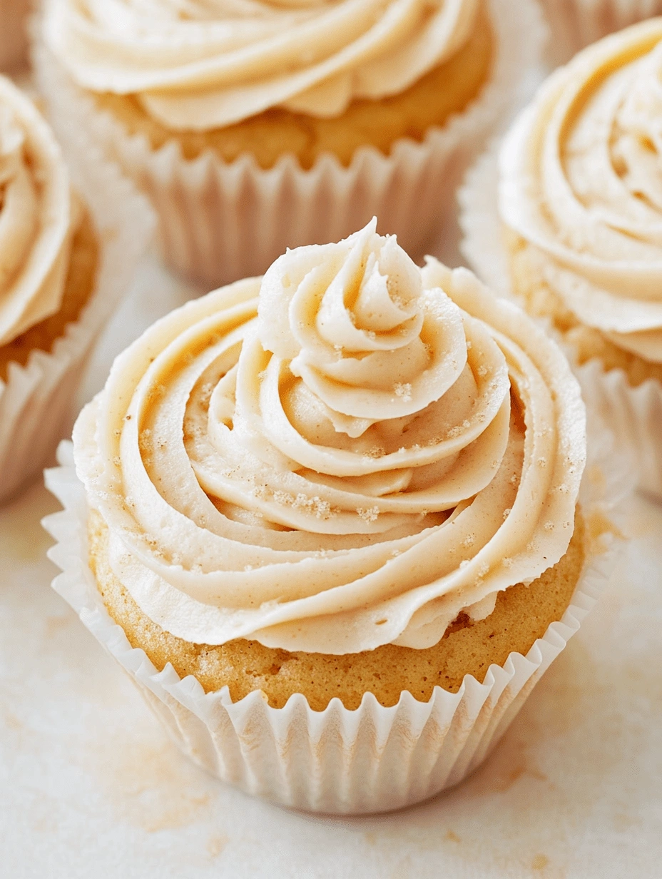 gluten-free-cupcake-with-cinnamon-sugar-frosting-closeup Close-up of a gluten-free cupcake with piped cinnamon-sugar frosting and a dusting of sugar, in a white paper liner.